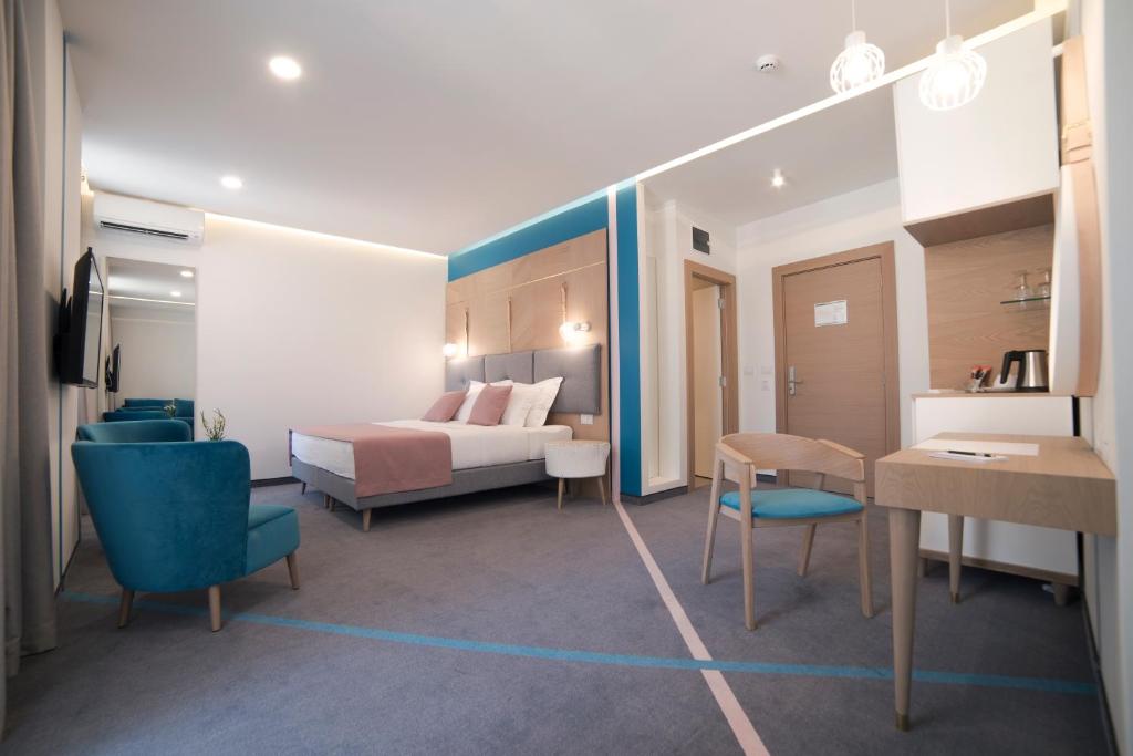 贝尔格莱德城市栖息地现代舒适套房旅馆的酒店客房带一张床、一张桌子和椅子