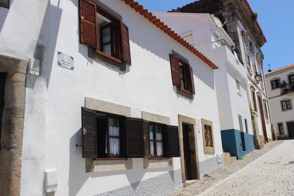 ProvesendeCasa Cimo Vila的白色的建筑,在街上有棕色百叶窗