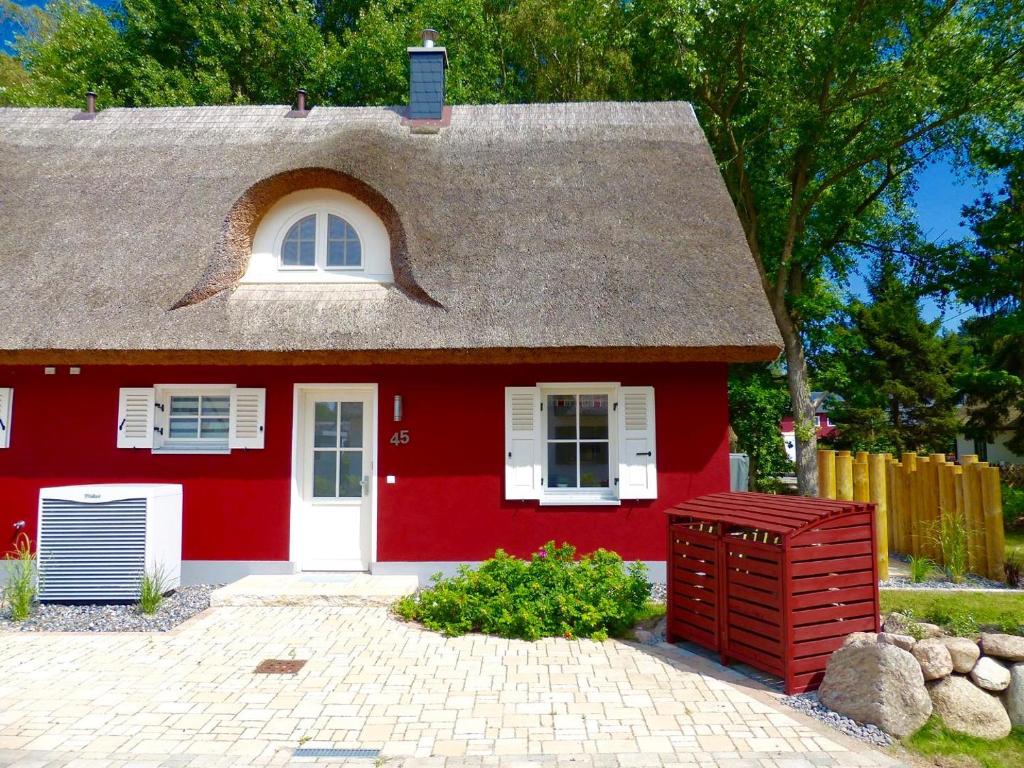 格洛韦Ferienhaus Stella的灰色的屋顶和白色的门的红色房子