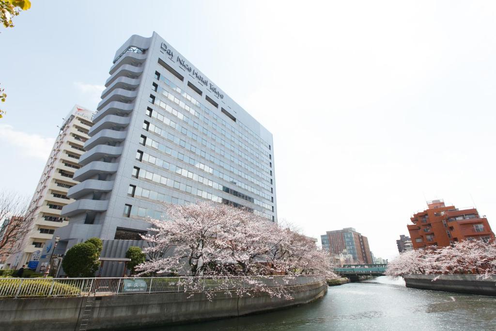 东京东京良日酒店的一条长满鲜花的河流旁的高楼
