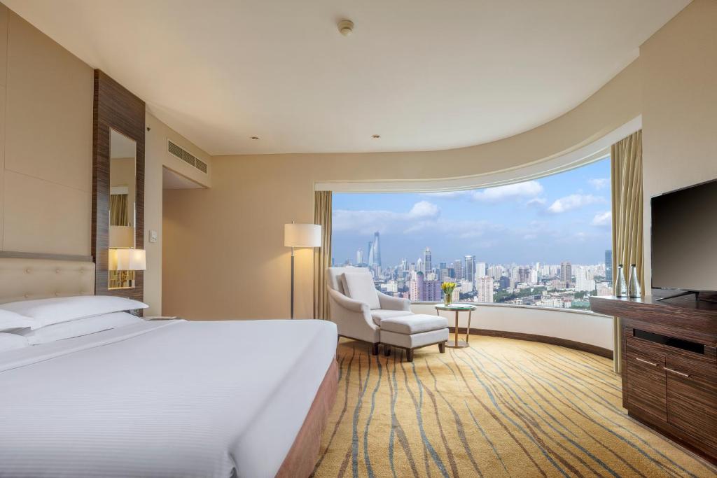 上海上海静安昆仑大酒店的一间酒店客房,设有一张大床和一个大窗户