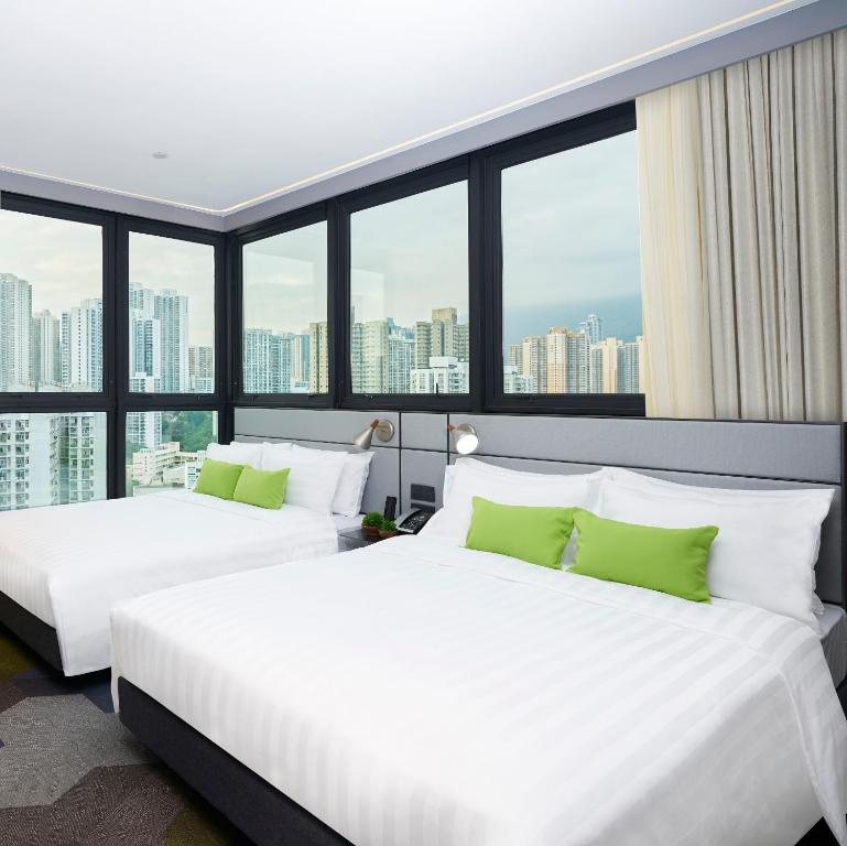 香港旭逸雅捷酒店 (荃湾)的配有大窗户的酒店客房内的两张床