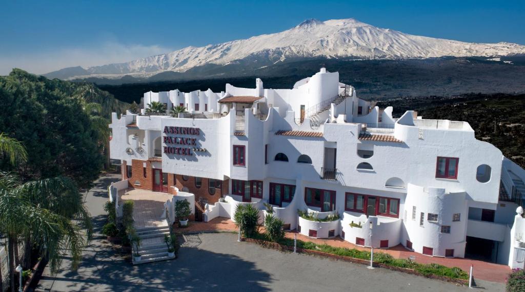 贾迪尼-纳克索斯艾斯诺斯宫殿酒店的一座白色的大建筑,背景是一座山