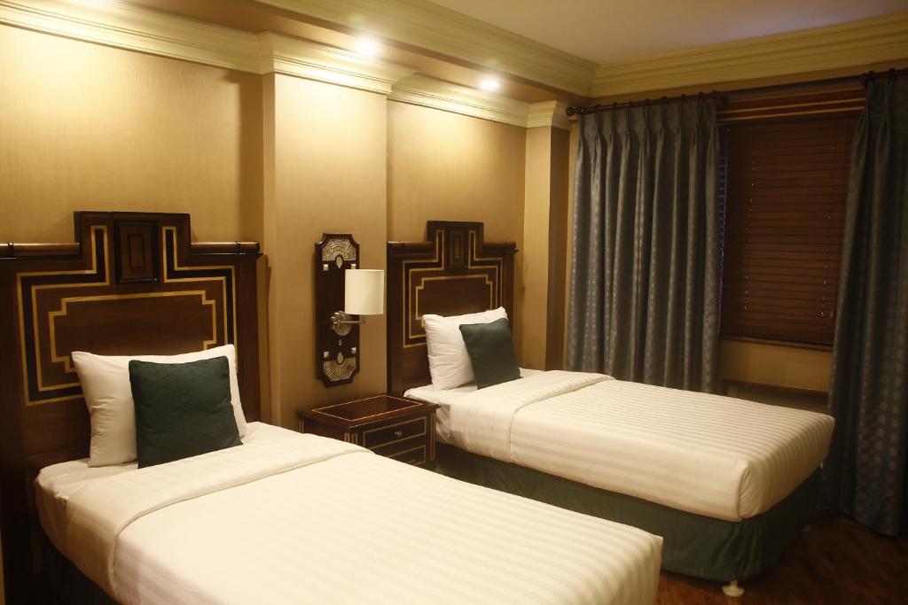 马尼拉Herald Suites Polaris的酒店客房设有两张床和窗户。