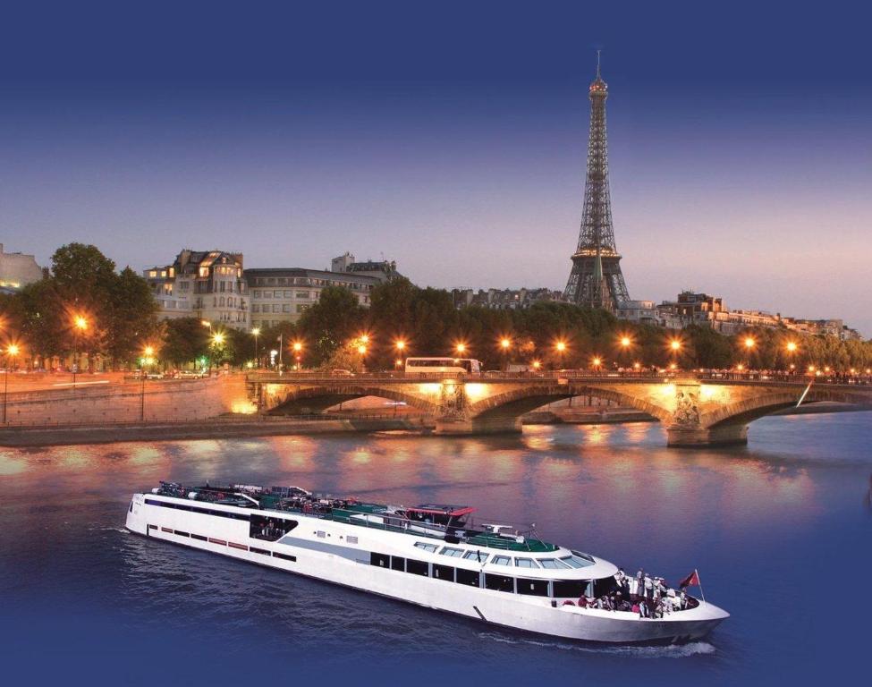 巴黎VIP Paris Yacht Hôtel & Spa的一条河上的小船,在艾菲尔铁塔前