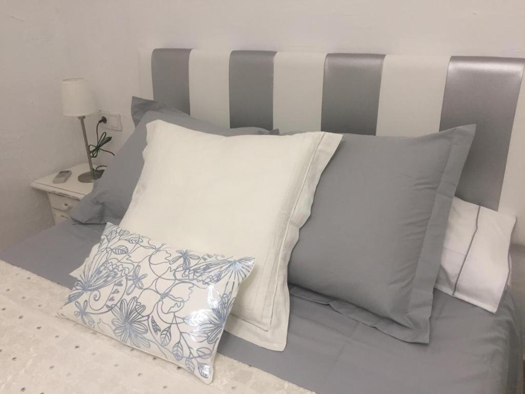 福恩吉罗拉La Casa de la Higuerita的一张带白色枕头的床和一个灰色床头板