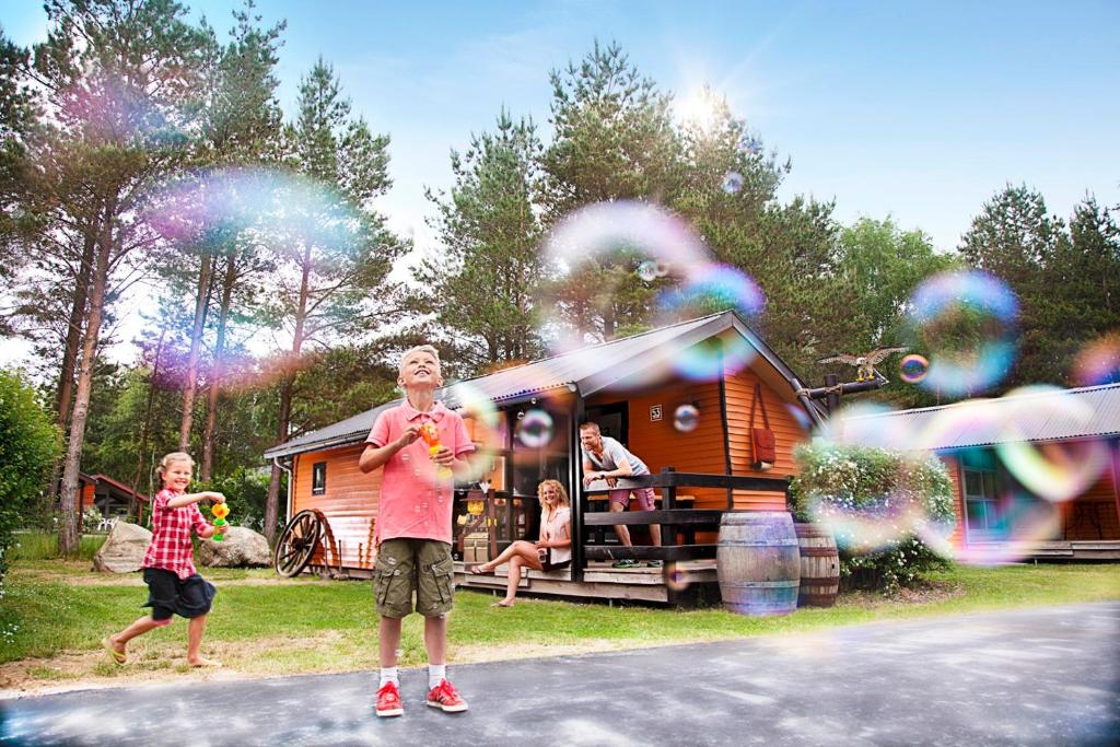 比伦德LEGOLAND Wild West Cabins的露营场地前的男人和孩子玩泡泡