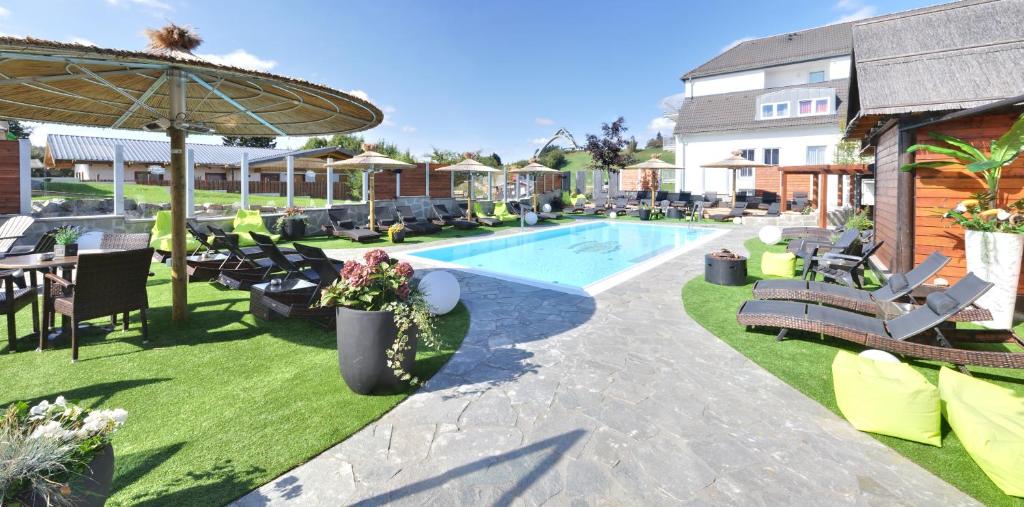 温特贝格布拉邦德度假酒店的一个带躺椅和桌子的游泳池