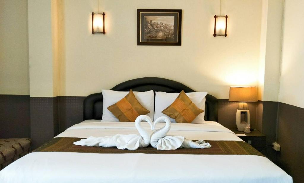 曼谷拜客套房旅馆的两只白天鹅坐在床上
