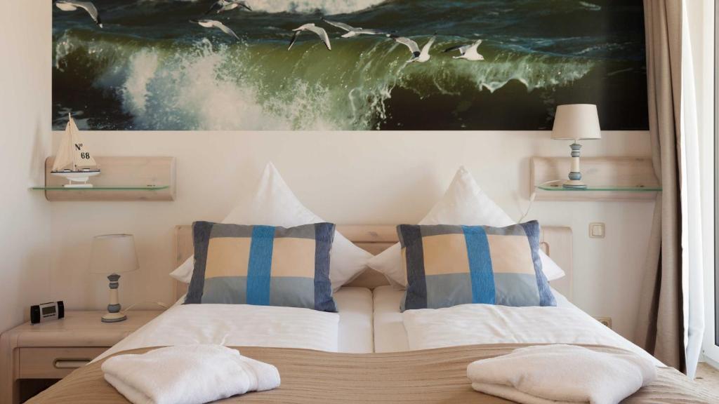 萨斯尼茨Villa am Kreidebruch _ Komfort_App的一间卧室配有带两个枕头的床和一幅画