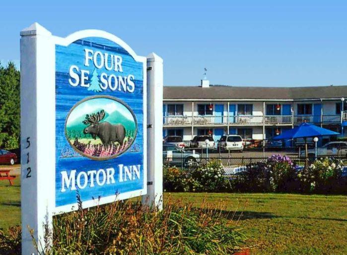 Twin MountainFour Seasons Motor Inn的标有荒野旅馆标志的酒店标志
