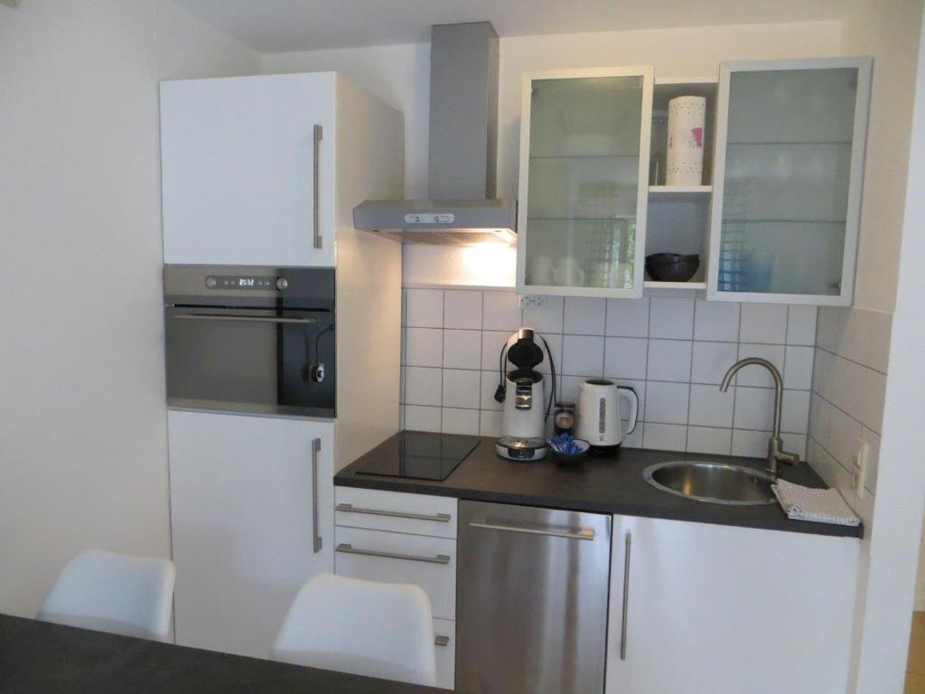 鲁斯特Ferienwohnung BELVEDERE的小厨房配有白色橱柜和水槽