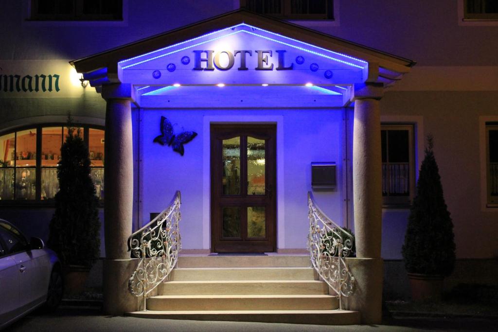 罗丁弗莱施曼潘森酒店的拥有蓝色灯的前门的酒店