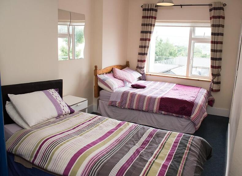 凯尔西温Sive Budget Accommodation的一间卧室设有两张床和窗户。