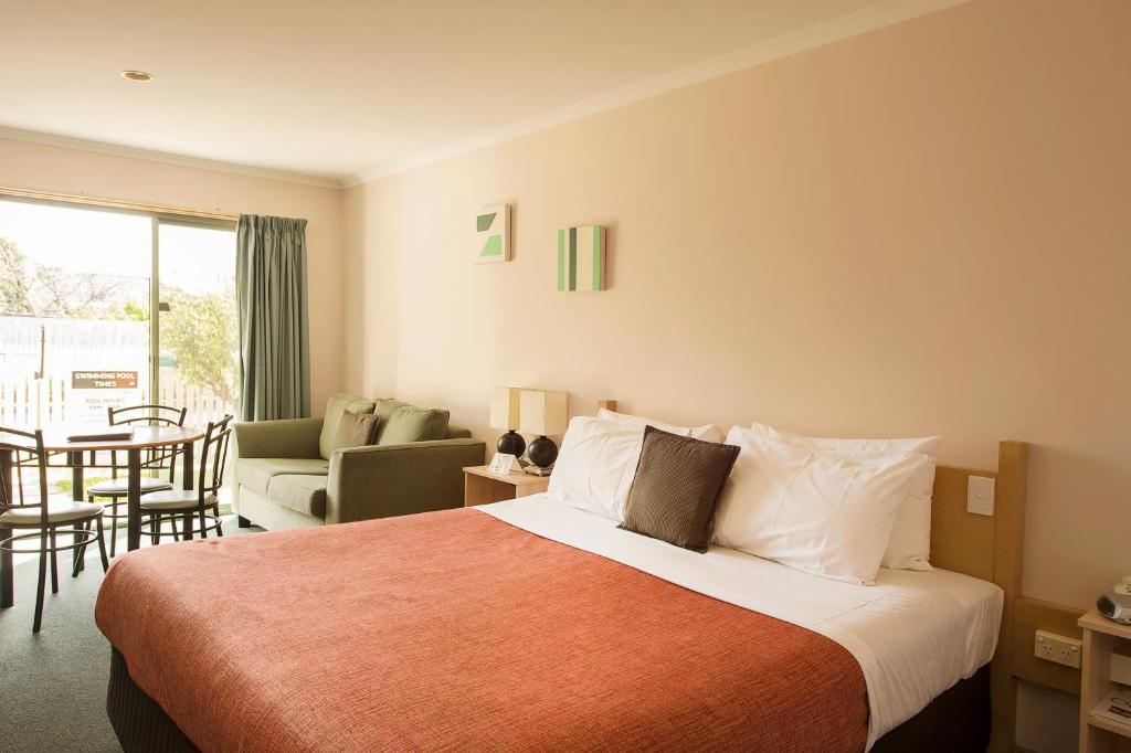 吉朗玫瑰园汽车旅馆的酒店客房设有床和客厅。