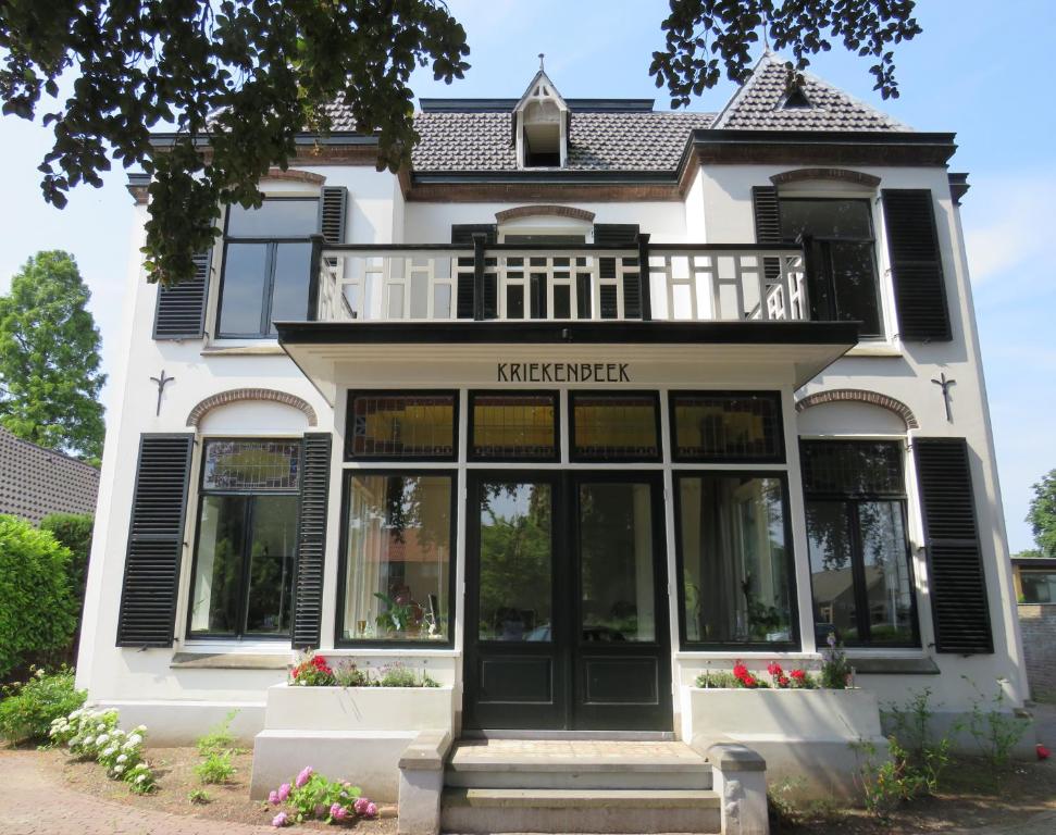 LentB&B Villa Kriekenbeek的白色的房子设有黑窗和阳台