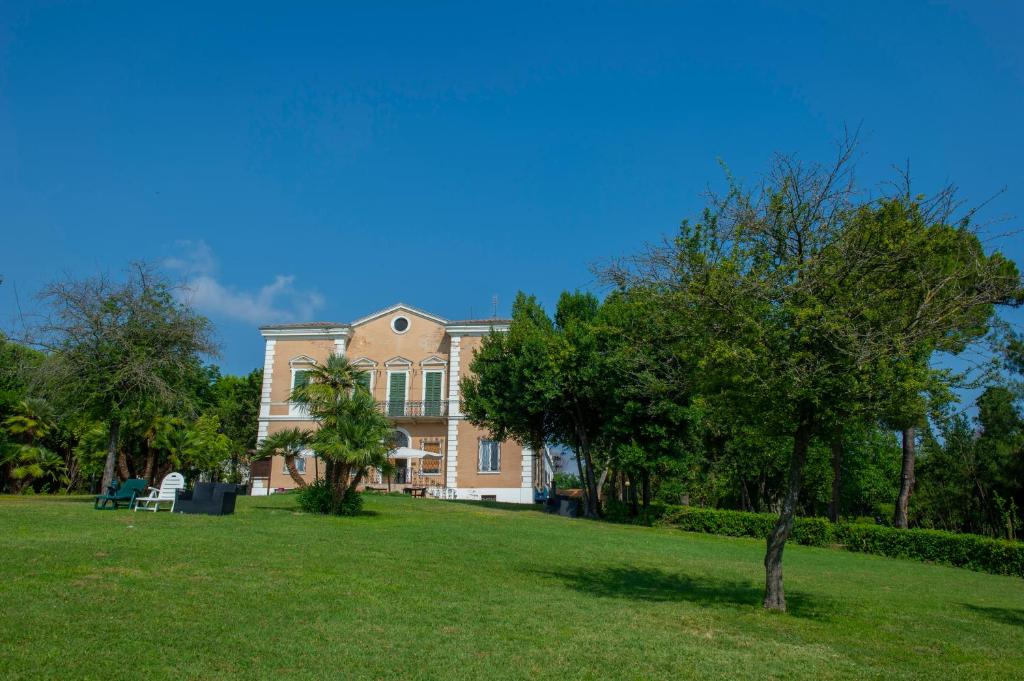 蒙泰马尔恰诺Tenuta Villa Colle Sereno的前面有一棵树的大房子