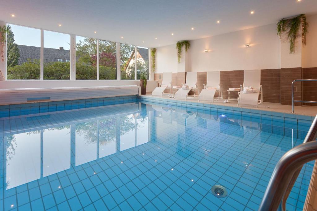 温特贝格安德烈豪斯酒店的一座带白色椅子的大型游泳池