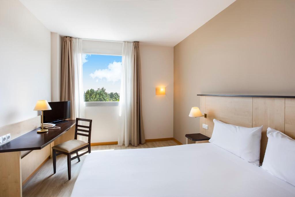 拉斯·罗萨斯·德·马德里B&B HOTEL Madrid Pinar de las Rozas的配有一张床、一张书桌和一扇窗户的酒店客房