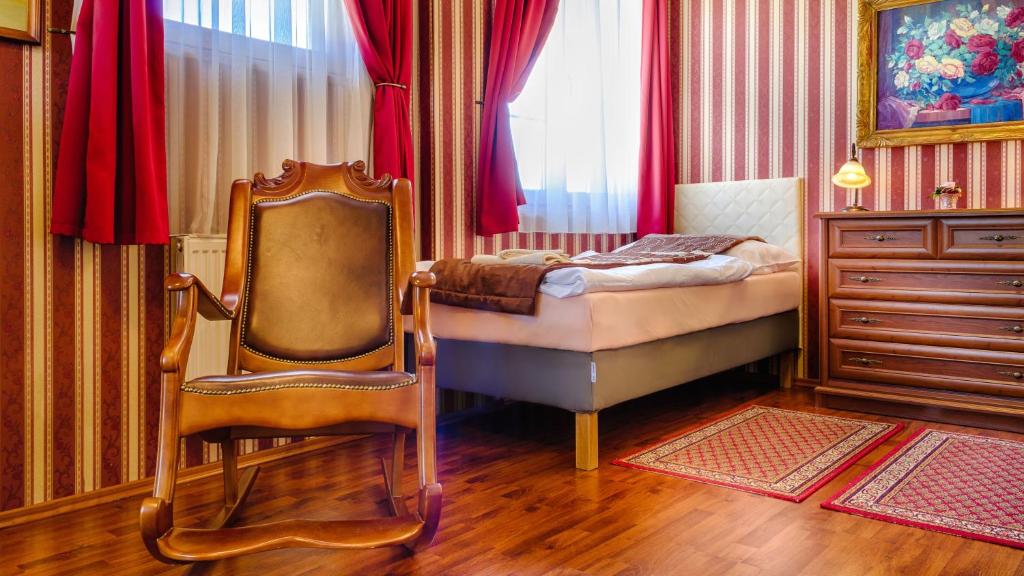 SládkovičovoHotel Tevel的一间卧室配有一张床、一把椅子和一个梳妆台