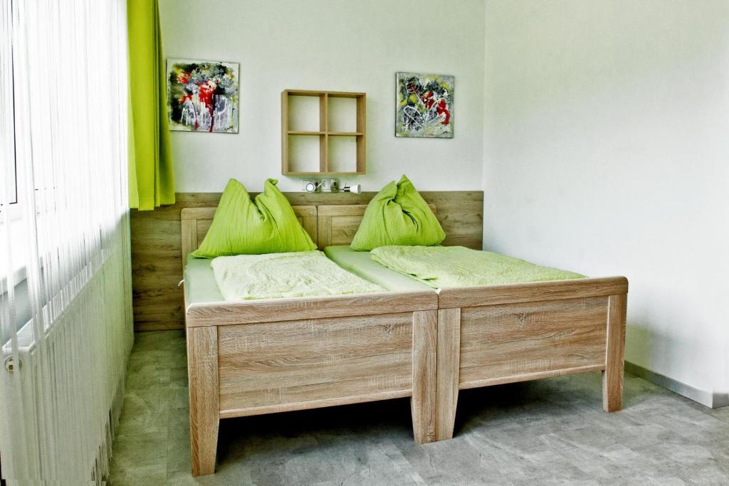 林茨Pension Waldesruh的一张带绿色枕头的木床