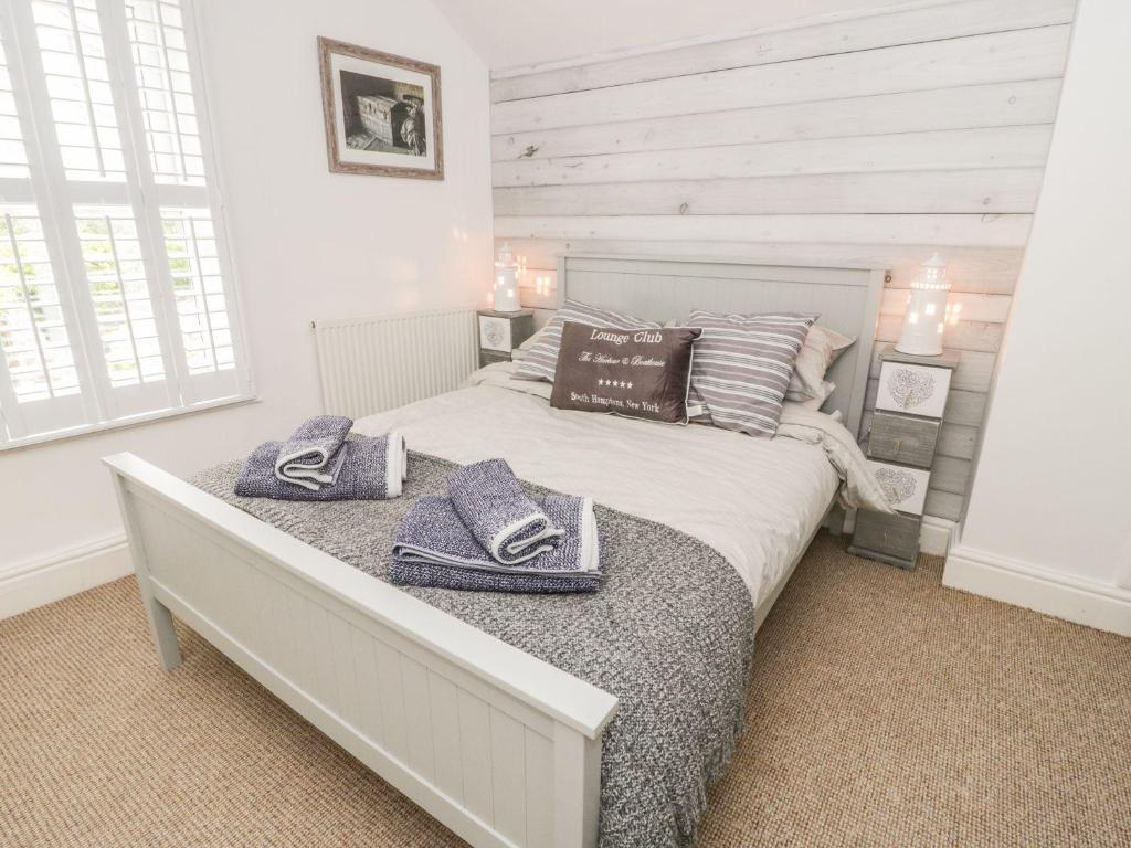 戴根威Sefton Cottage的一间卧室配有一张床,上面有两条毛巾