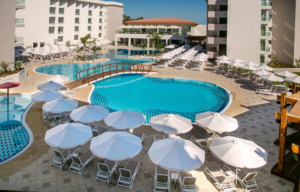 普罗塔拉斯Vangelis Hotel & Suites的一组遮阳伞和椅子,位于游泳池旁
