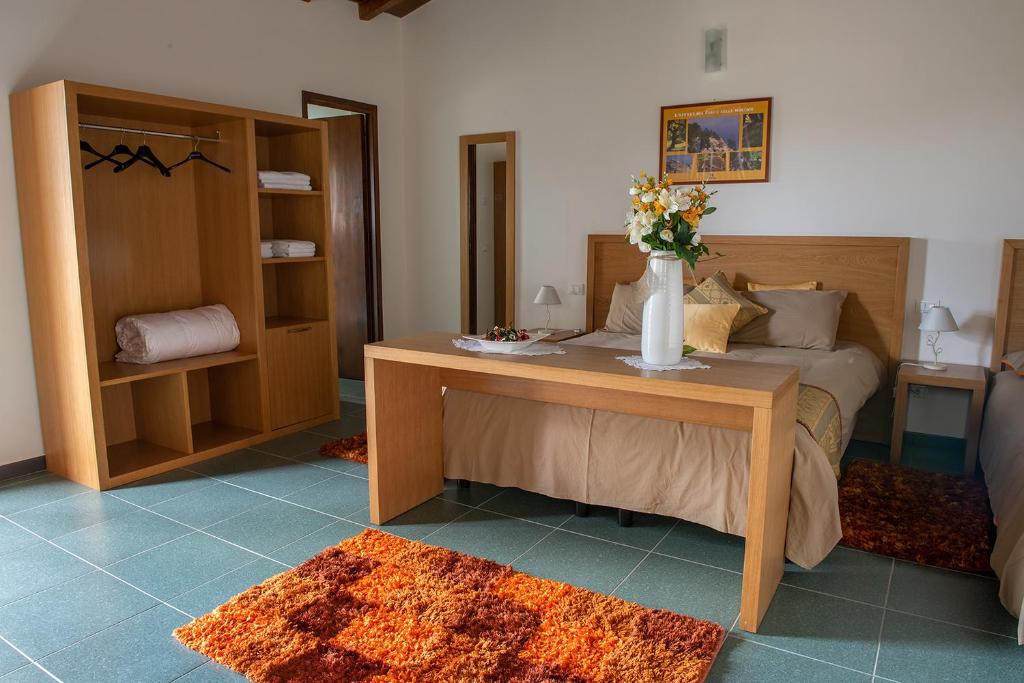佩特拉利亚索普拉纳Antico Resort Cerasella的一间卧室配有一张床和一张鲜花桌子