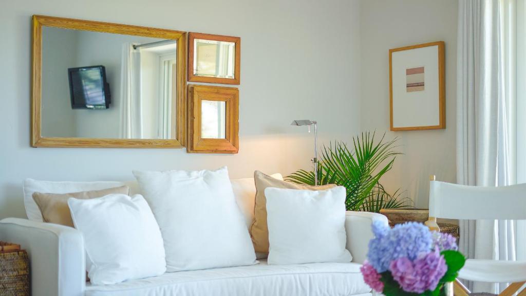 阿默甘西特迎风海岸度假酒店的客厅配有带枕头的白色沙发,配有镜子