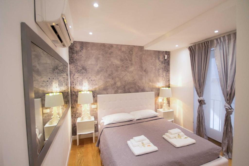 罗马维亚德尔科索公寓的一间卧室配有一张带两条白色毛巾的床