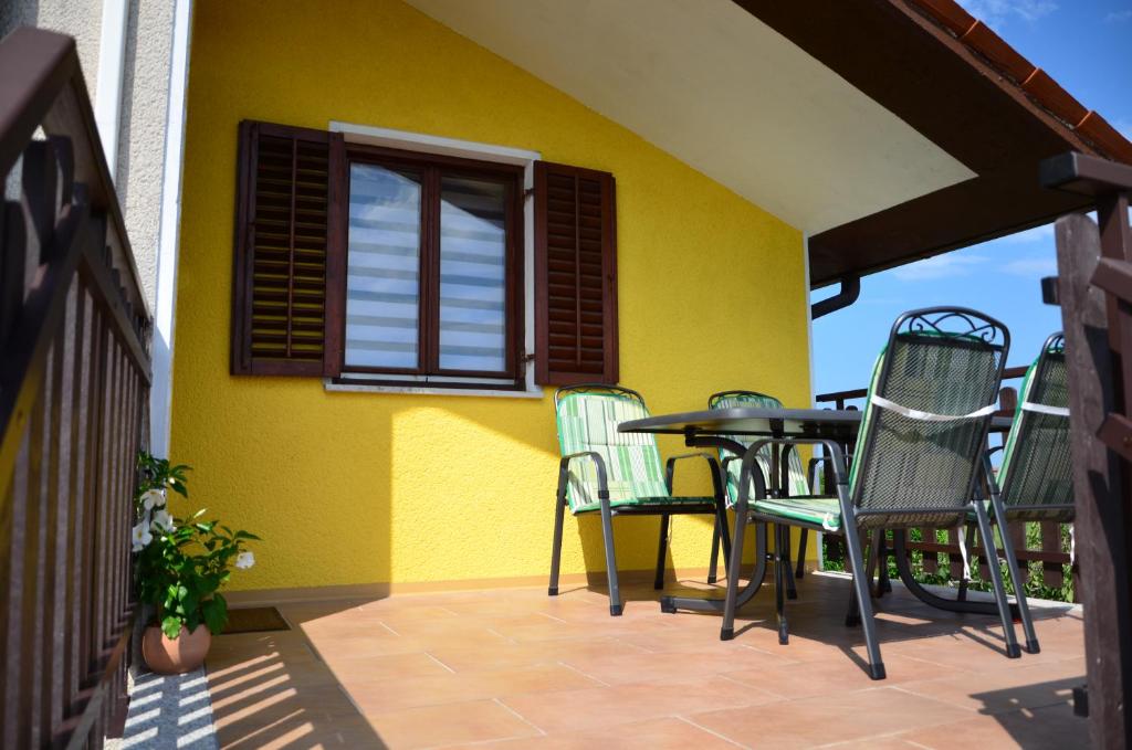 DutovljeApartma Louis的庭院配有桌椅和黄色墙壁
