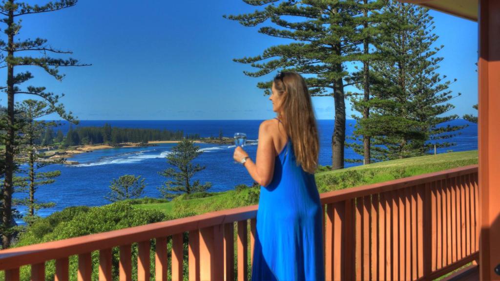 彭特派因海鸥美景别墅的站在一个眺望着水面的阳台上的女人