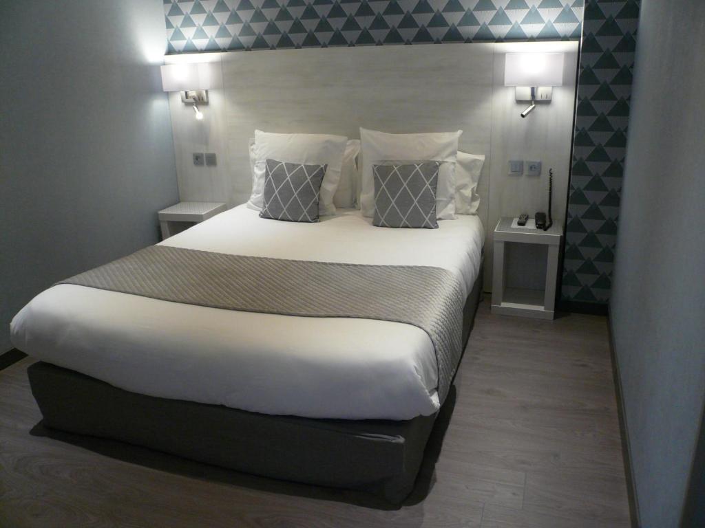 塔布流洛品酒店的卧室配有一张带白色床单和枕头的大床。