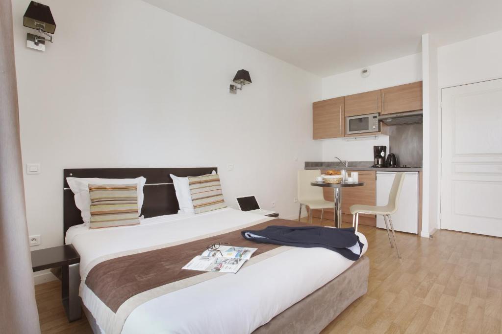 博索莱伊博索莱伊奥达利斯城市豪斯德拉普林斯普特公寓式酒店的一间带大床的卧室和一间厨房