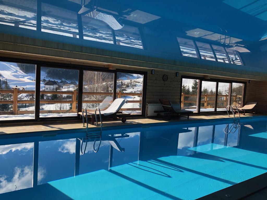 布克维Chalet du Mont的一座享有雪景的建筑内的游泳池