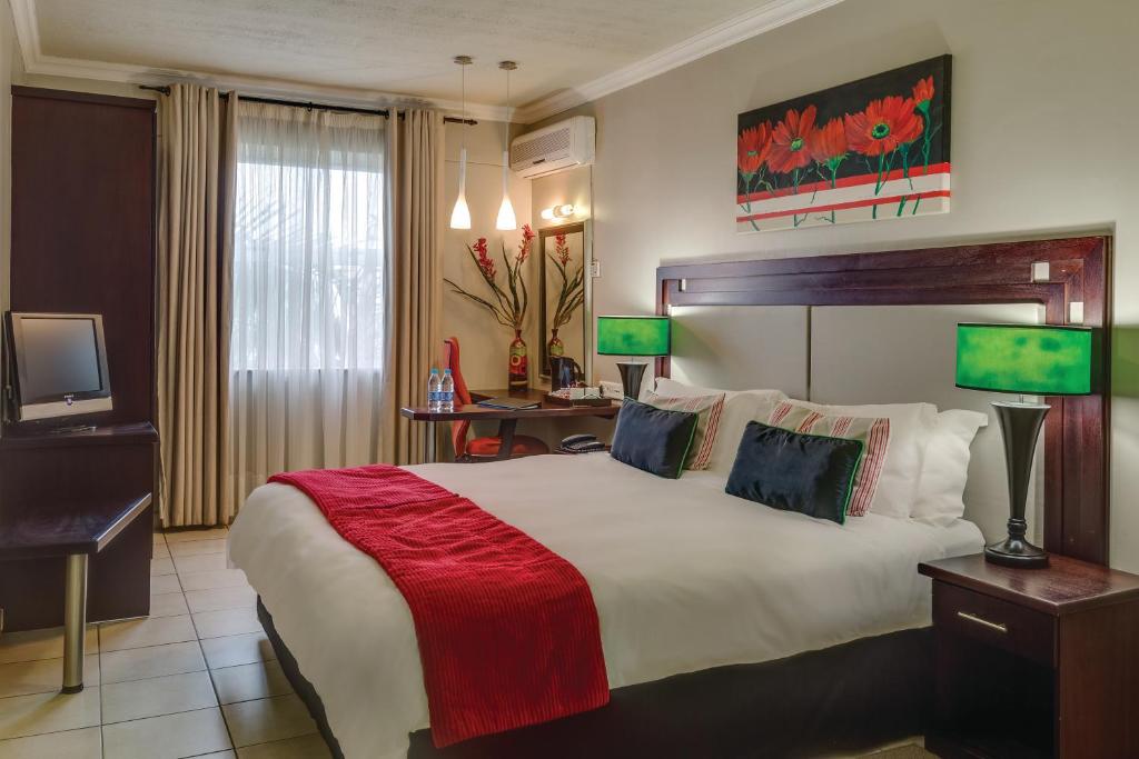 恩潘盖尼BON Hotel Empangeni的酒店客房设有一张大床和一台电视。