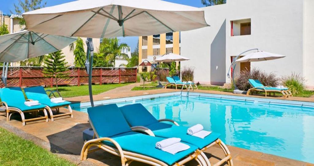 基苏木The Vic Hotel的一个带蓝色椅子和遮阳伞的游泳池