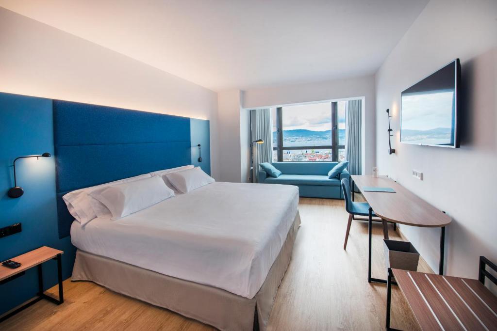 维戈Occidental Vigo的一间卧室配有一张床、一张桌子和一张沙发