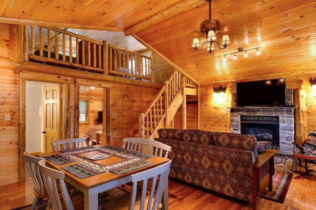 普莱西德湖Cobble Mountain Lodge的客厅配有桌子、沙发和壁炉