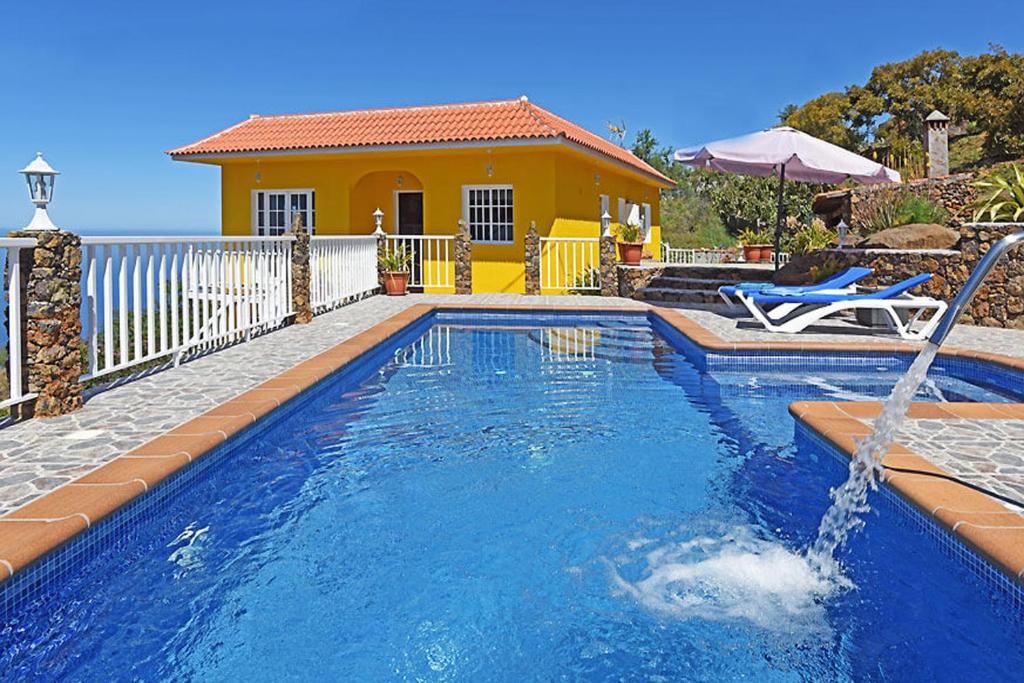 蒂哈拉费Villa La Hoya的一座房子前面带喷泉的游泳池