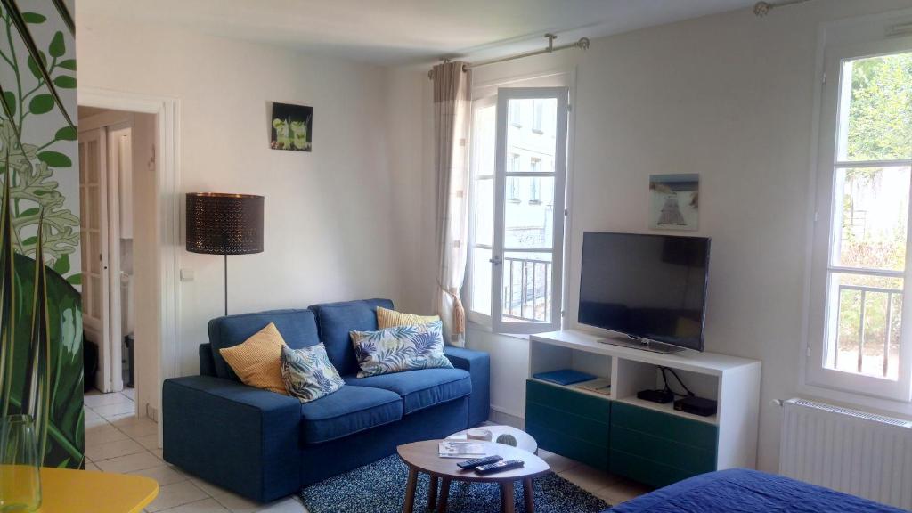 翁弗勒尔Le Studio 54的客厅配有蓝色的沙发和电视