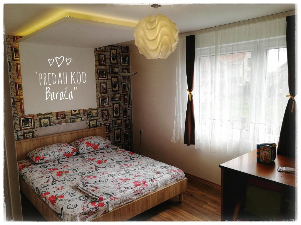 尼什Apartments "Predah kod Baraća"的卧室配有一张挂有墙上标志的床