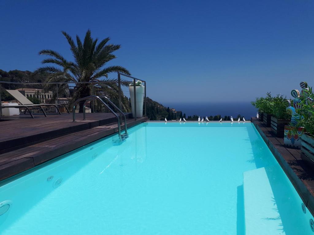 陶尔米纳伊尔皮克罗贾迪诺GH***高级酒店的大型蓝色游泳池,享有海景