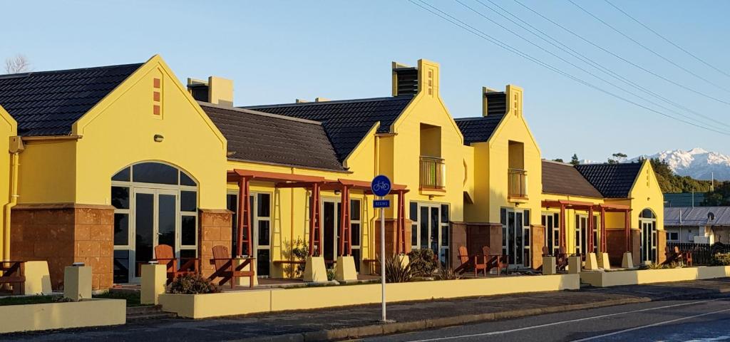 凯库拉The Anchor Inn Beachfront Motel的街上一排黄色的房子