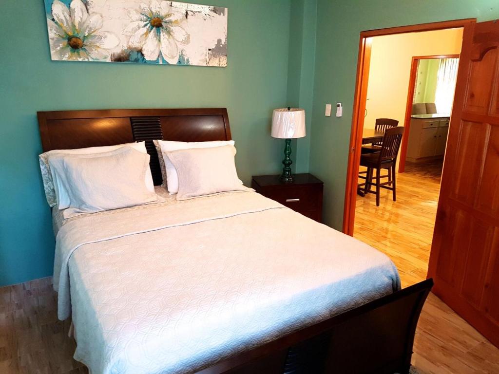 Mount IrvineParadise Place Apartments的一间卧室配有一张带白色床单的大床