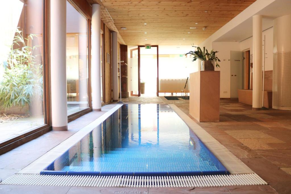 施伦斯Relax & Vitalhotel Adler的一座带房子的建筑中间的游泳池
