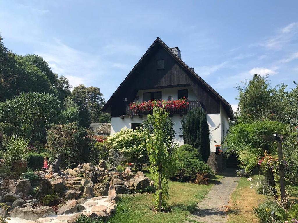 永斯多夫佩特斯赫勒家庭式度假酒店的白色的房子,有黑色的屋顶和花园