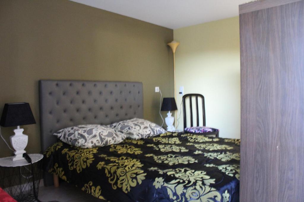 Fauverney福韦尔内旅馆的一间卧室配有一张带黑白色棉被的床