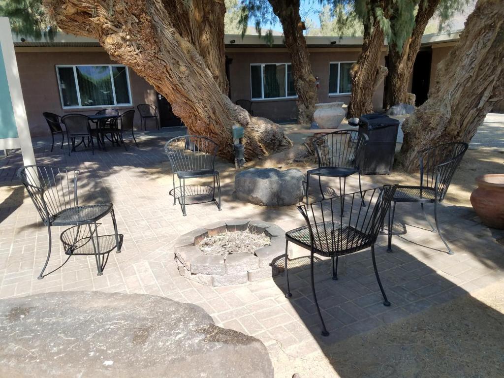 Shoshone肖肖尼汽车旅馆的树下一组椅子和一个火坑