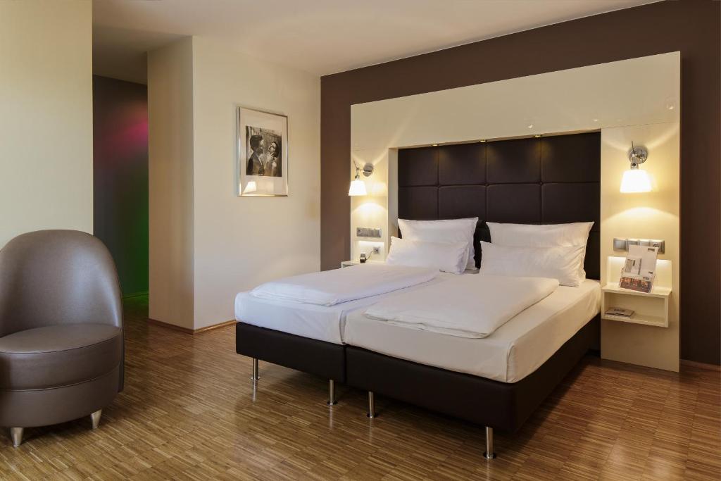 科隆圣多酒店的一间卧室配有一张大床和一把椅子